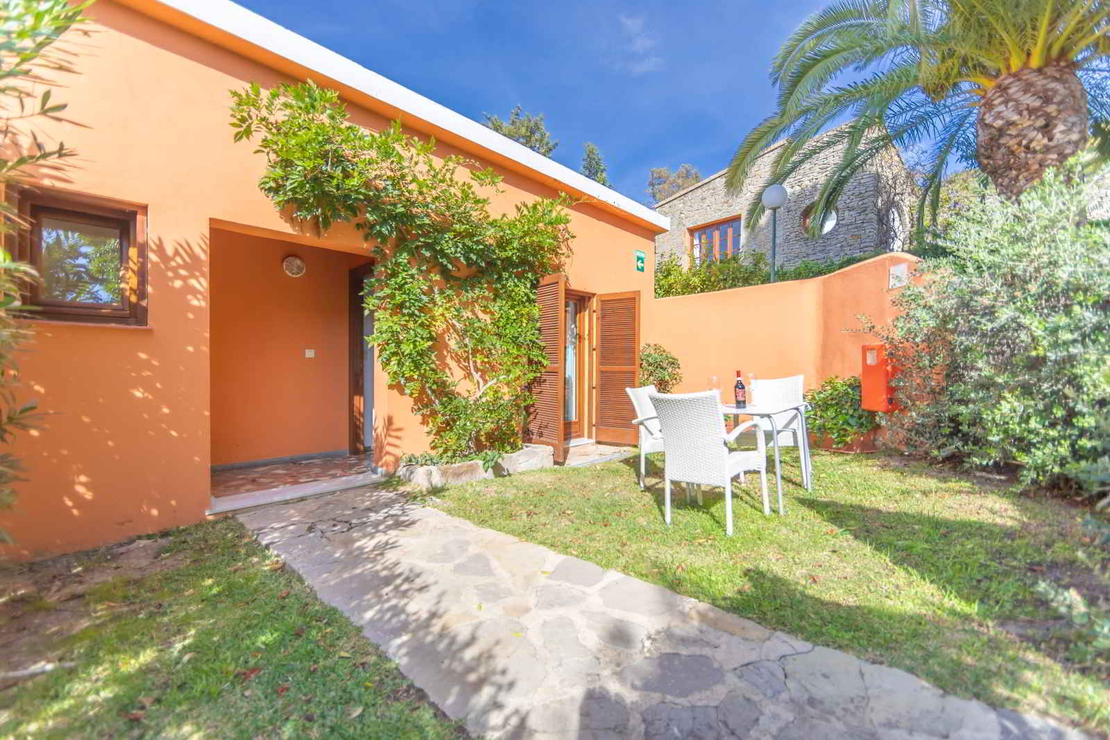 Fachada exterior de habitación familiar con jardín privado, acceso independiente y zona de mesa exterior en Hotel Punta Sur.