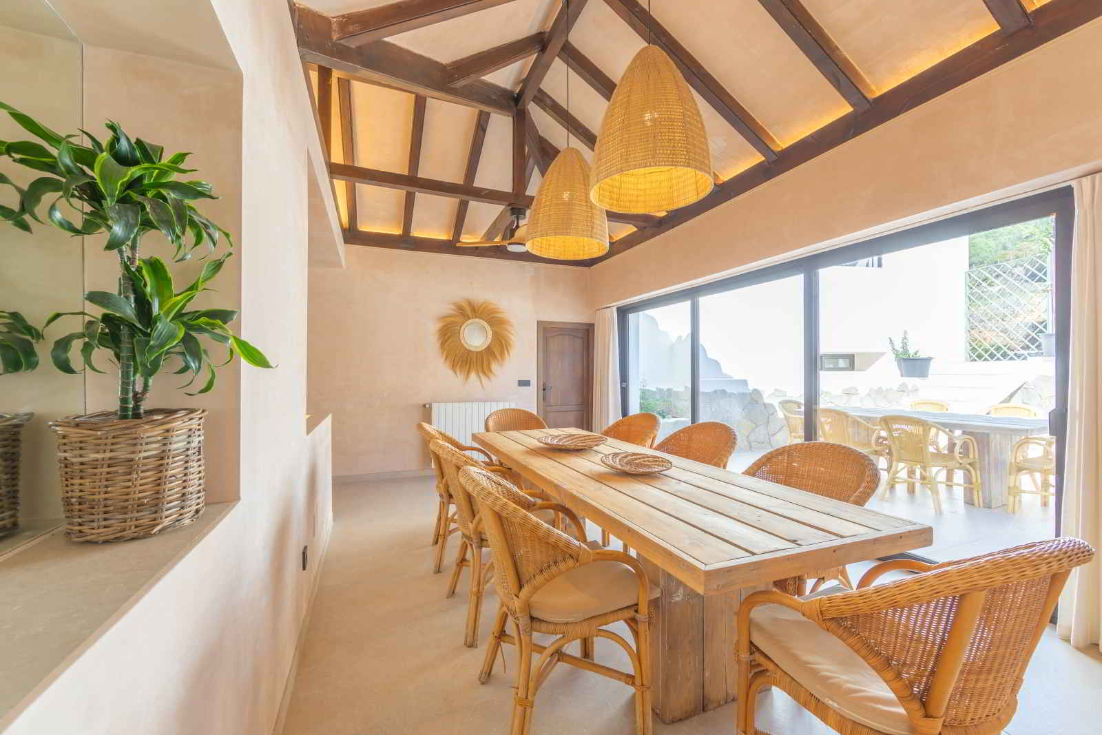 Comedor interior de La Villa del Hotel Punta Sur con techo de madera, decoración natural y grandes ventanales con vista a la terraza exterior.