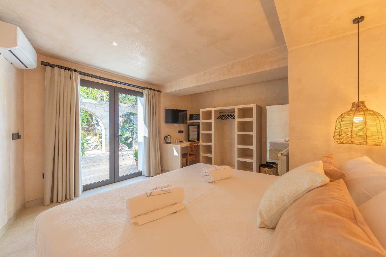 Dormitorio de La Villa en Hotel Punta Sur con cama doble, acceso directo a la terraza, detalles en tonos cálidos y mobiliario funcional.