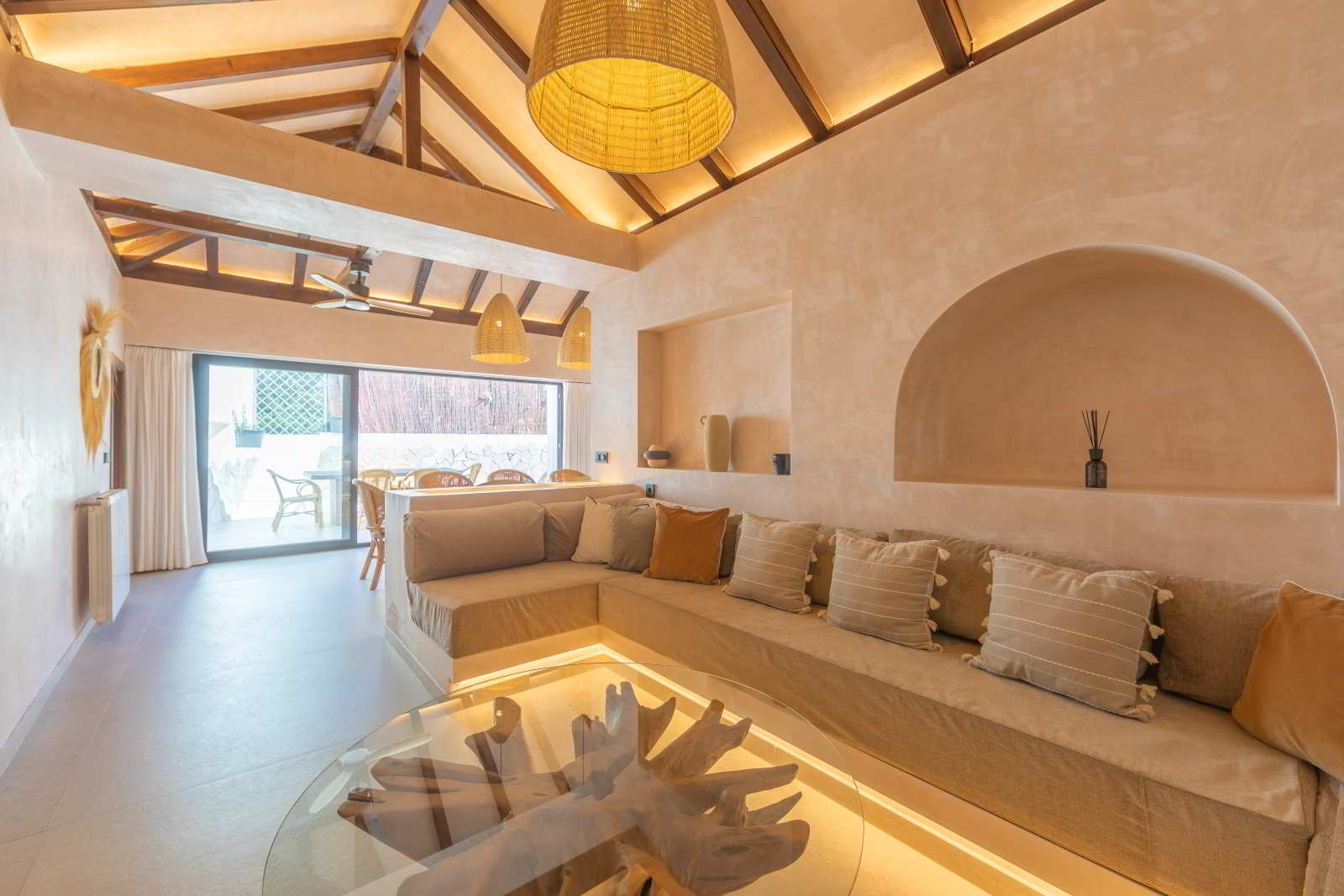Salón abierto y luminoso de La Villa del Hotel Punta Sur con sofá esquinero y techo de madera.